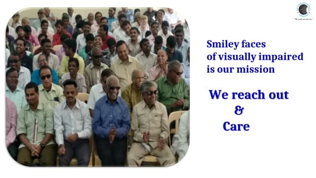 A large group of visually impaired men seated closely together at an event, many smiling and clapping